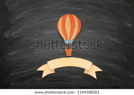 Hot air balloon cut from paper and painted over blackboard background