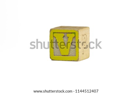 Distressed vintage yellow and white toy block, photographed against a white background. The letter V.