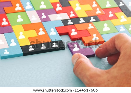 image of tangram puzzle blocks with people icons over wooden table ,human resources and management concept Royalty-Free Stock Photo #1144517606