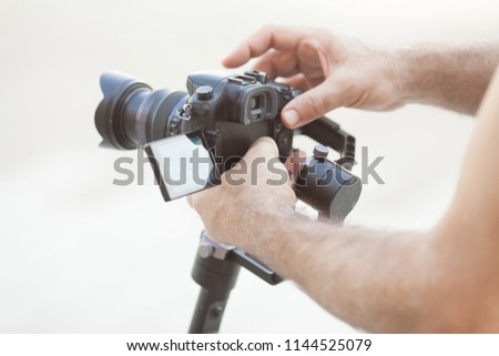 Close up old male hands hold professional camera