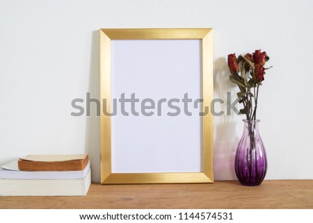 Blank gold frame on wooden table.home decoration