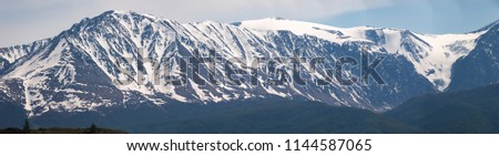 Mountain peaks covered with snow, a panorama of several pictures taken with a long-focus lens. North-Chuysky Range, Altai Republic, Russia.