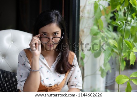 Asian women are holding glasses and smiling at a coffee shop on a holiday.