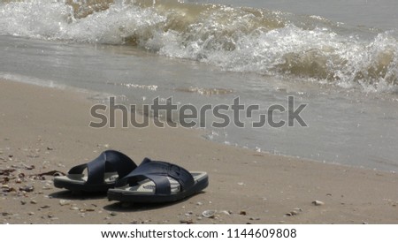 Soft waves on the beach. Slippers on the beach.
