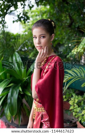 Young beautiful girl wearing thai traditional costume and looking to the camera