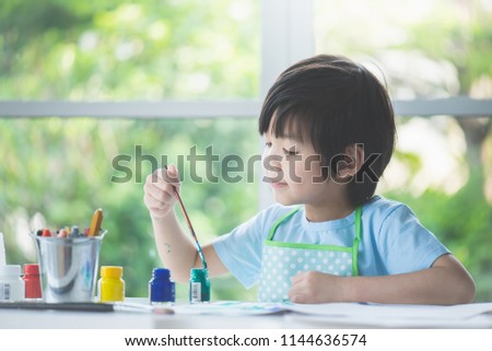 Cute Asian boy painting a picture