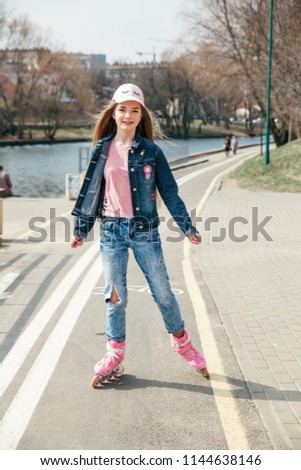 Little pretty girl on roller skates in park