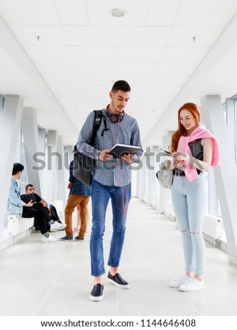 Two young students read a book at the University. The photo illustrates education, College, school, or University.