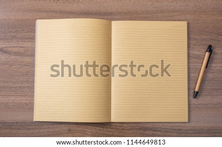 Open blank school notebook or diary and pen, old fashioned, on wooden desk, space for text, top view