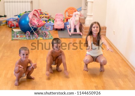 Three little children do exercises. concept of a healthy lifestyle. Little children do sit-ups