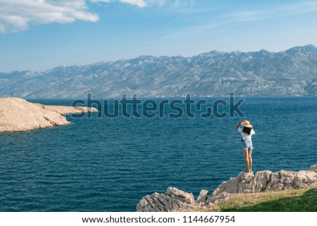 Concept picture of traveling. Woman looking at scenic view by the sea at pag island in Croatia, 