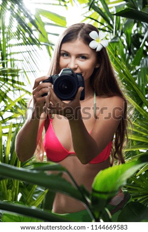 portrait of nice young woman is taking picture in the  jungle