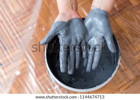 female hands mixing paint, human home activity, paint dripping down, getting ready for decorating or refurbishing 