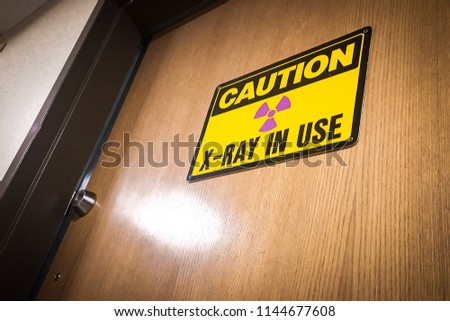 “CAUTION: X-RAY IN USE” warning sign posted on locked door.
