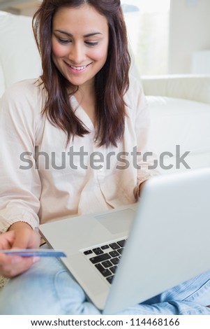 Woman happily shopping online on laptop in living room