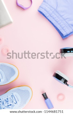Woman sneakers, headphones, fitness tracker and running clothes on pastel background. Sport fashion concept. Flat lay