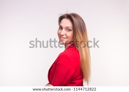 Portrait of young woman in a red suit posing on white background with copy space