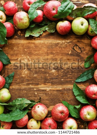 Ripe red apples with leaves on wooden background. Shallow dof.