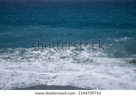 Nice marine background. Bright blue color with white splashes and foam. Place for text. Seascape. Beautiful picture. 