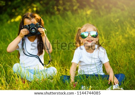 Two children girl(female, woman) hold a camera take a picture each other(together) with smile(happy)