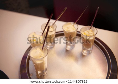 Creamy ice cream in small glasses on a tray.