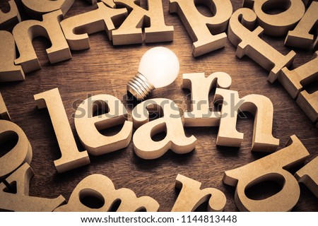 LEAEN word by wood letters with glowing light bulb Royalty-Free Stock Photo #1144813448