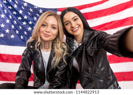 girls with dark and fair hair taking picture of themselves as thet are best friends. country concept. international re lationship