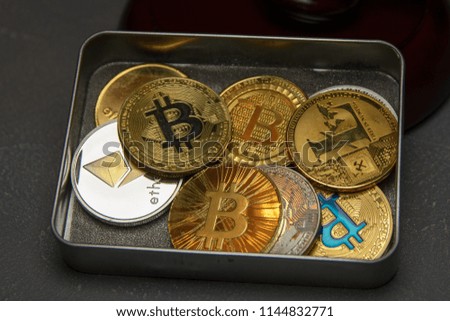  golden bitcoin and litecoin in metal box beside judge gavel