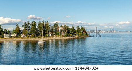 Secluded residences on Bainbridge Island with skyline of Seattle in the background, WA, USA Royalty-Free Stock Photo #1144847024