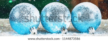 Three blue New Year balls on the snow. Christmas atmosphere.