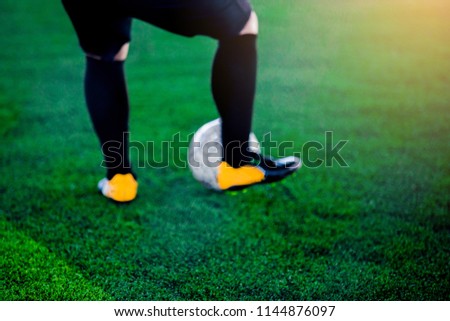 Blurry picture of Soccer player shoot ball on artificial turf. For background.