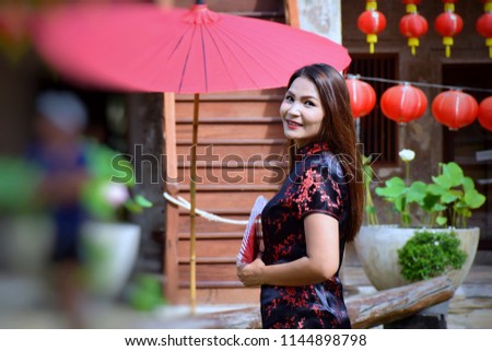 Asian Girls in Cheongsam Dress and hold the Chinese blow and Chinese red lamp at Landmark of Heritage sites and Chinese architecture, bangkok, thailand