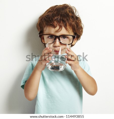Portrait of boy drinking glass of water isolated in white Royalty-Free Stock Photo #114493855