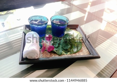 Thai style Welcome drink set with beautiful flower orchid and freshness cold towel on rectangle handmade local wooden plate for customer in resort hotel summer season.