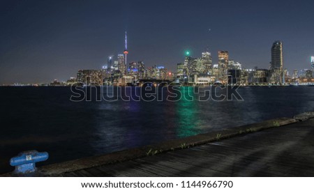 Toronto skyline over lake at night time
