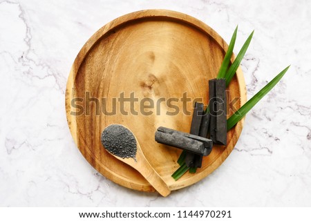 Bamboo charcoal and powder on marble table. copy space Royalty-Free Stock Photo #1144970291