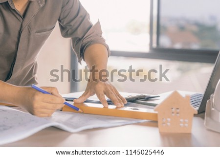 civil architect engineer drawing plan on wood table,engineering and architect concept.Blue print is fake only for stock photo.