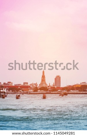 view of traditional ferry boat or old passenger boat go across from port to another port at chao phraya river. Wat Arun at background. thailand travel concept filtered image