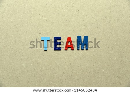 Colorful Alphabet letter in word "TEAM" on wood background