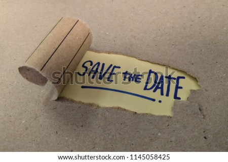 Torn brown paper revealing the words Save the Date. 