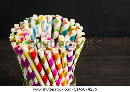 Paper straw of different colors on dark background with copy space Royalty-Free Stock Photo #1145074256