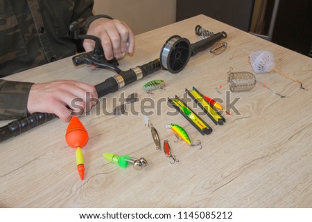 Fisherman prepare to fishing. Tools and accessories on wooden table. Composition with accessories for fishing on a wooden background