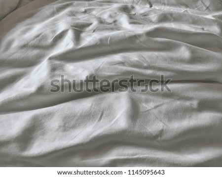 Top view of the crease of an unmade bed sheet in the bedroom after night sleep and waking up in the morning.