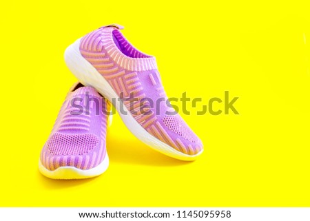 purple sport shoes on a yellow background Royalty-Free Stock Photo #1145095958
