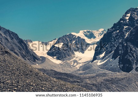 Mountains with snow caps in a dark tinting. Altai mountains Siberia Russia