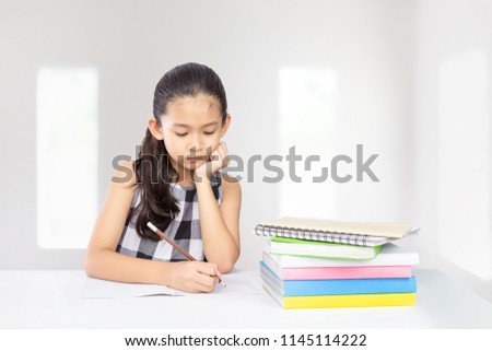 Cute asian kid concentrate on her homework a concept for education 