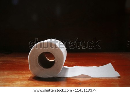 Soft roll unwound in the way of toilet paper on the wood board.