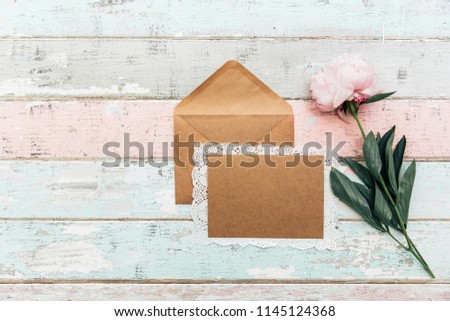 Beautiful pink peony,card with envelope on vintage background. Top view, flat lay. Invitation greetings concept