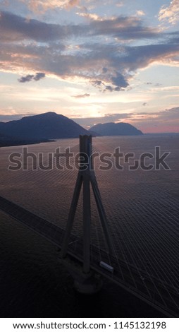 Aerial bird's eye drone photo of state of the art suspension bridge crossing the sea at sunset