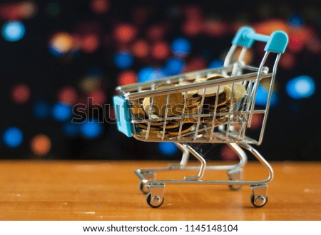 shopping cart and coins with blur background. E commerce or financial saving concept.